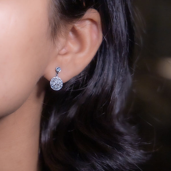  white gold diamond earring with multiple smaller diamonds set around it.